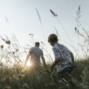 Boy and his father walking in nature at sunset